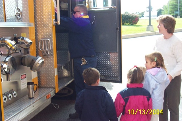 Firefighter Ed Gouge gives a tour of Ladder 22 at Helping Hearts Day Care
