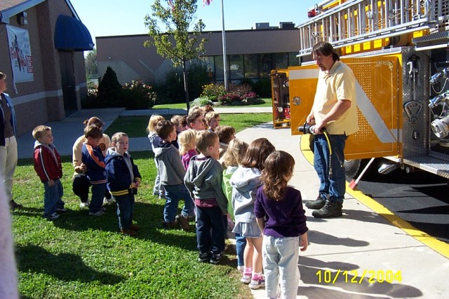 Firefighter Craig Miller explains rescue tools at the Helping Hearts Day Care