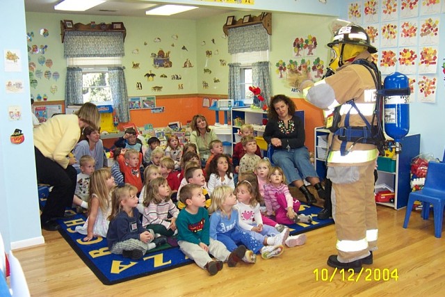 Fire prevention coordinator and fightfigher/EMT Lisa Glass shows the class at Helping Hearts Day Care what full gear looks like 