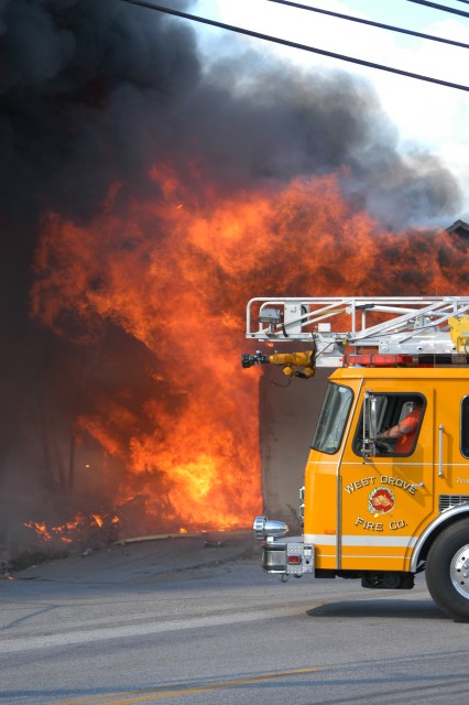 Engineer Lary Hicks positions Ladder 22 with fire showing, Route 796