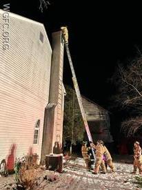 A WGFC firefighter inspects the chimney atop a 35" ground ladder at a home in New London Township. 