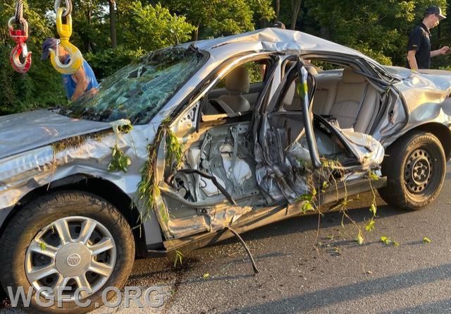 After the sedan has been removed from off the road back to the roadway, the force of the crash is evident in the damage.  