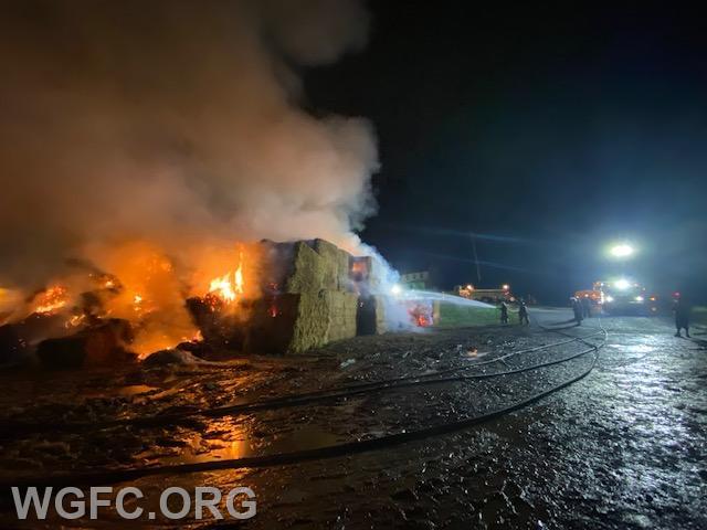 WGFC firefighters darken down the fire while compost crews moved bales away from the burning pile.