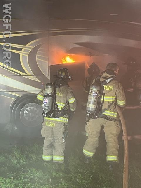Firefighters work to extinguish the fire from a side compartment.