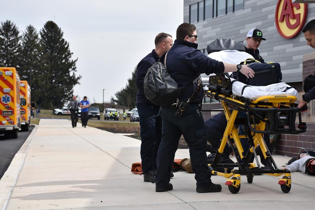 Avondale's ambulance crew arrives at the school as a member of the PA State Police escorts a victim to the treatment area.