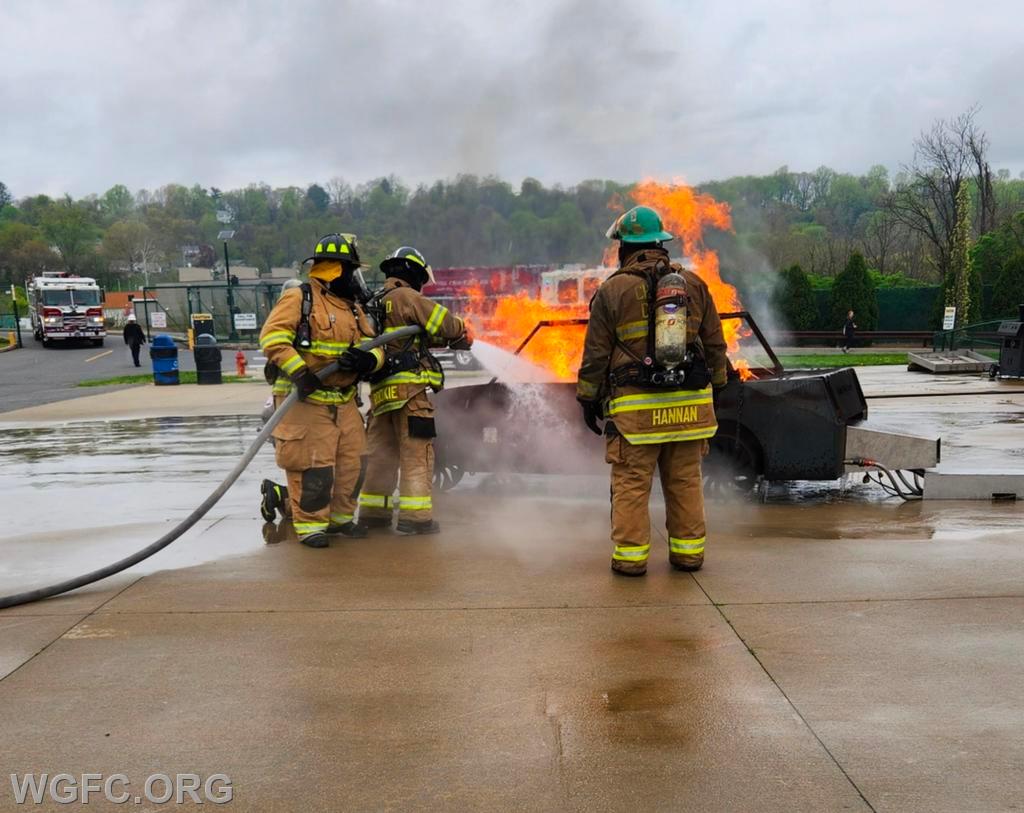 Fire school students demonstrate handling a simulated car fire during friends & family day at the Chester County Public Safety Training Campus.