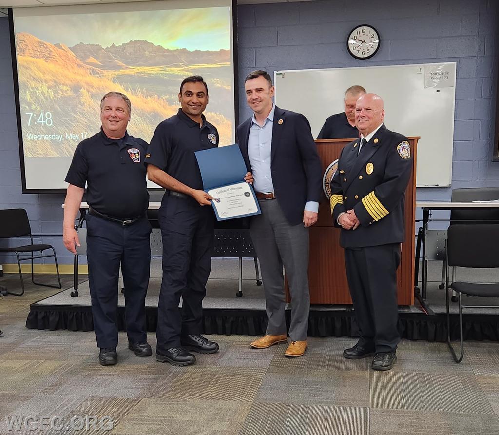 Assistant Chief Keiser presents Firefighter Sudini his certificate.